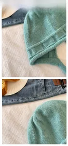 Close-up of mint green chunky knit trapper hat with soft earflaps and tie straps