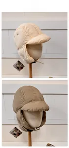Detail of windproof winter trapper hats with ear flaps in beige and coffee colors