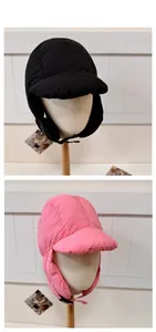 Detail view of winter earflap hat with brim in black and pink windproof fabric