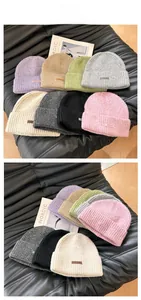Close-up of ribbed knit beanies in multiple colors with stylish pipisweet leather labels