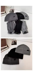 Detailed view of knitted winter beanie and thermal gloves set in grey and black tones