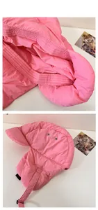 Close-up of pink padded winter trapper hat showing windproof fabric and buckle details