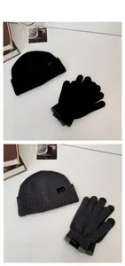 Flat lay detail of rib-knit winter beanie and matching gloves in black and charcoal grey
