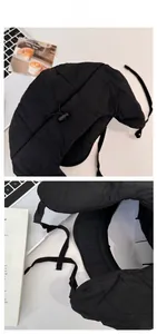 Detail of black quilted trapper hat with back adjustable drawstring and ear flaps
