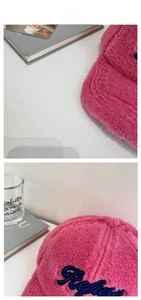 Détail de la casquette de baseball en polaire rose avec broderie bleue 'Refuse' dessus