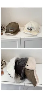 Detail of winter trapper hat showing warm white faux fleece lining and letter embroidery