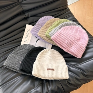Collection of knitted beanies with leather patch labels in eight autumn colors