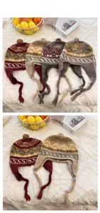 Detail of colorful jacquard knit earflap hat with decorative pom-poms and braided tassels