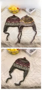 Detail of hand-woven jacquard knit hats with colorful pompoms and braided ties for winter