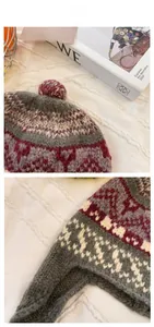 Detailed view of handmade vintage jacquard knit hat with ear flaps and colorful pom-poms