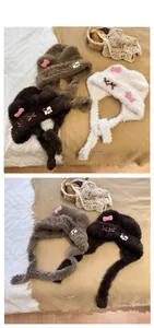 Three plush earflap hats in brown, grey, and cream with cute bows and cat patterns