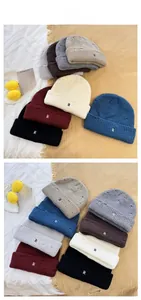 Close-up of knit beanies with R-letter embroidery and distressed ripped details