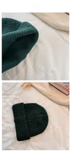 Detail of dark green knit beanie featuring chunky wave texture and warm fleece properties