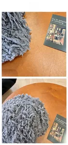 Detailed view of the gray plush baseball cap featuring long fringe and textured fiber finish