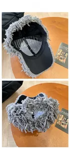 Detailed view of gray fuzzy plush baseball cap with long tassels and breathable black mesh lining