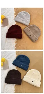 Detailed tile display of knitted beanies with R letter embroidery and distressed holes