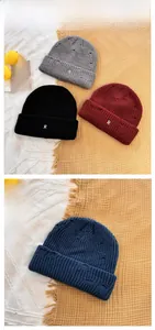 Close-up of distressed knit beanies with embroidered R letter in four classic colors