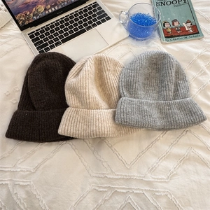 Three chunky knit beanies in coffee, beige, and grey with a warm ribbed texture