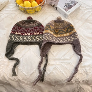 Handmade colorful jacquard knit beanie with earflaps and pompom for winter warmth
