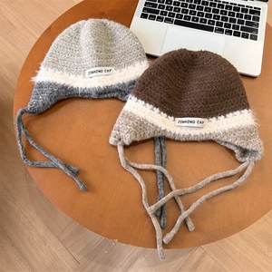Bonnet trappeur tricoté main avec brides à nouer contrastées et étiquette tissée