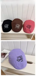 Detail view of colorful newsboy caps with dog embroidery and street style design