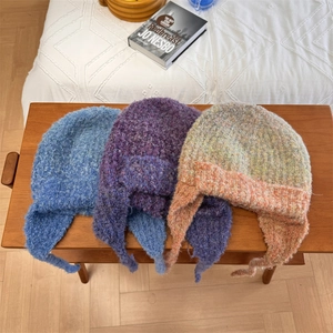 Three gradient wool blend knitted trapper hats with long ties in various winter colors