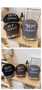 Detailed view of distressed baseball caps with graffiti paint splatters and embroidery
