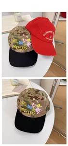 Detail of camouflage and red baseball caps with unique embroidery and vintage distressed style