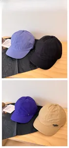 Detail of short brim baseball caps in four colors with Never Give Up side embroidery