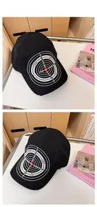 Detail of distressed embroidery on black cotton baseball cap with target pattern