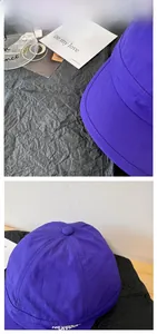 Detail of dark purple quick-dry cap with Never Give Up white embroidery on short brim