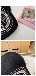 Detail view of black vintage baseball cap with white circular embroidery and distressed style