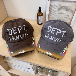 Distressed baseball cap with graffiti spray paint on a vintage wooden shelf