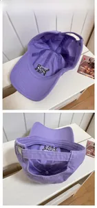 Detail view of purple cotton baseball cap featuring embroidered cat inner lining and metal buckle