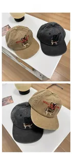 Detail of washed cotton baseball caps with dog embroidery and text on a modern white shelf