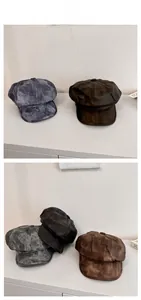 Detail of vintage newsboy caps in washed dark grey and distressed brown leather texture