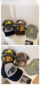 Detail of distressed baseball caps with heavy embroidery and vintage washed hole design
