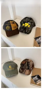 Close-up of four distressed baseball caps with embroidery and camouflage patterns