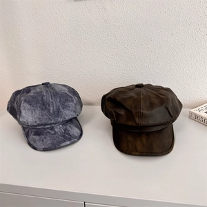 Vintage PU leather and washed grey octagonal newsboy hats displayed on a white table