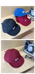 Three quick-dry outdoor baseball caps in black, red, and blue with mountain patches