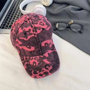 Berretto da baseball leopardato rosa e nero a tesa larga su una scrivania di moda