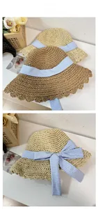 Detail of hand-woven straw hats with large bow ribbons and decorative wavy edges