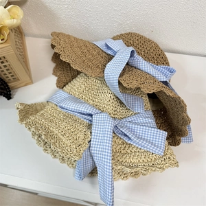 Women's summer straw sun hats with wide wavy brims and blue gingham ribbon bows