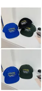 Detail view of cotton twill baseball caps with vintage embroidery in blue and green
