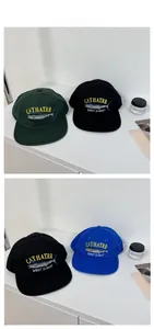 Close-up of vintage embroidered baseball caps in royal blue, black, and dark green colors