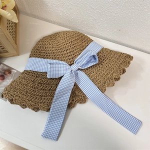 Straw sun hat with blue gingham bow and wavy brim for summer beach vacation