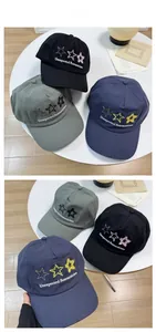 Detail of embroidered stars and romanticism text on cotton baseball caps in three colors