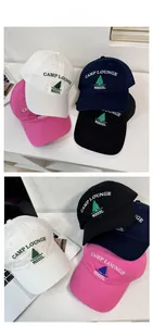 Detail of embroidered Camp Lounge logo and pine tree pattern on assorted cotton baseball caps