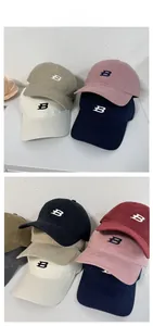 Detail showing various colors of baseball caps with embroidered letter B on cotton fabric