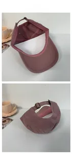 Detail of dusty pink canvas baseball cap showing internal seams and metal buckle